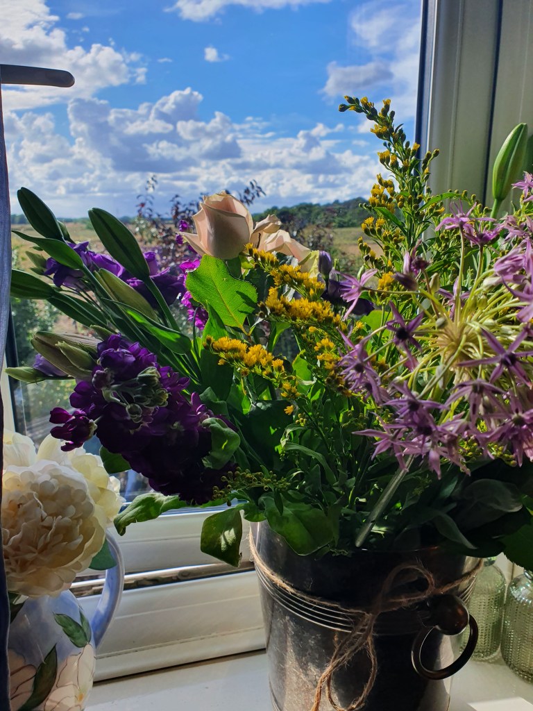 Bouquet in Metal Wine Cooler On a Blue Sky Windowsill