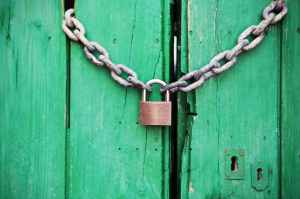 An Emerald Green Door Locked With A Chain And Padlock