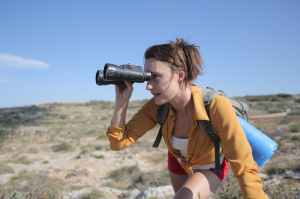 Woman Looking Into The Distsnce With  Binoculars